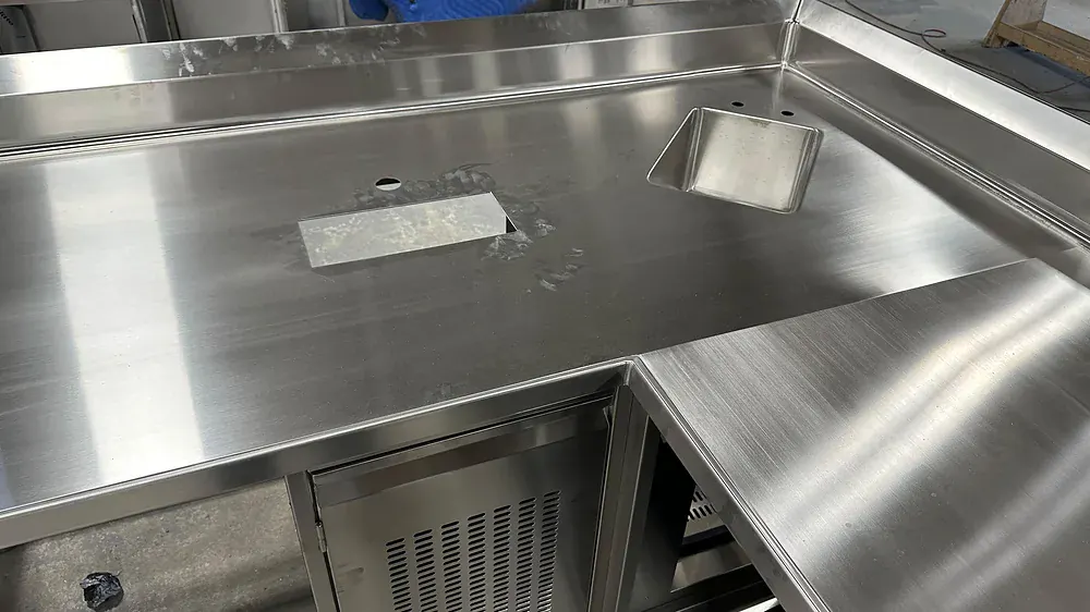 Finished stainless counter with drop-in well and cut-out, on the shop floor
