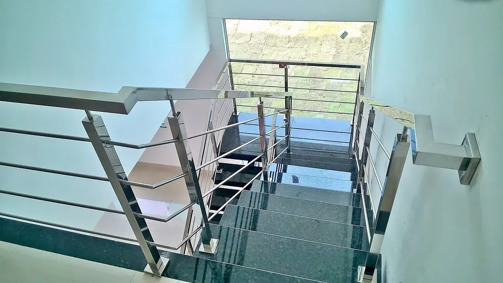 Stainless stair guardrail with horizontal balusters, seen from the landing of a finished stair